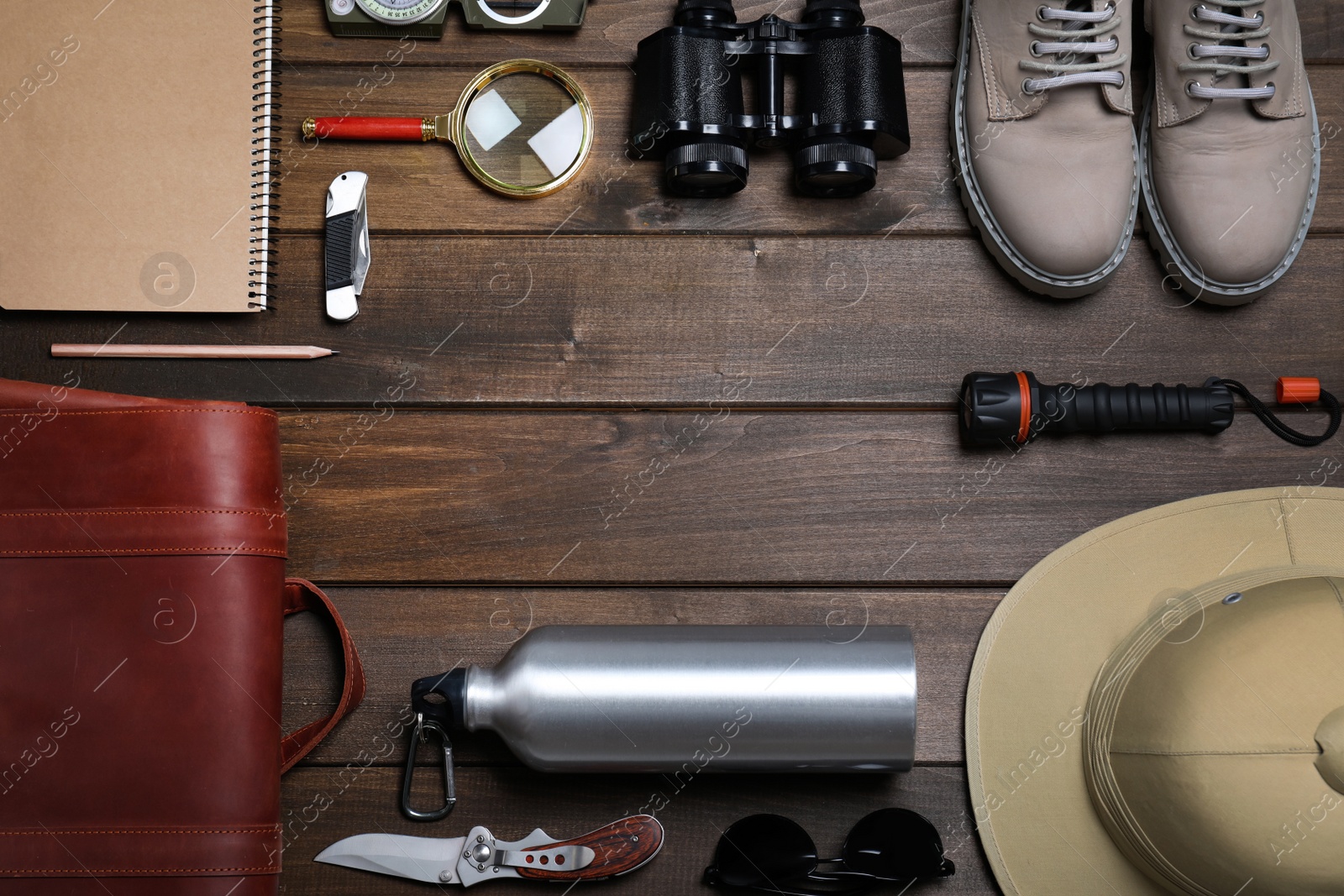 Photo of Frame of different safari accessories on wooden background, flat lay. Space for text