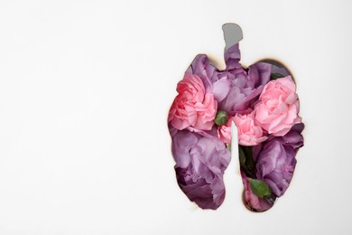 No smoking concept. Top view of flowers through burned lungs shaped paper, space for text