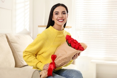 Happy woman with red tulip bouquet at home. 8th of March celebration