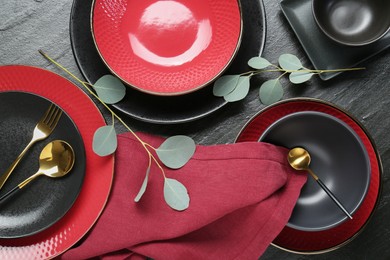 Flat lay composition with stylish ceramic plates and floral decor on grey table