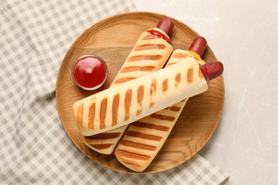 Photo of Delicious french hot dogs and dip sauce on light grey table, top view
