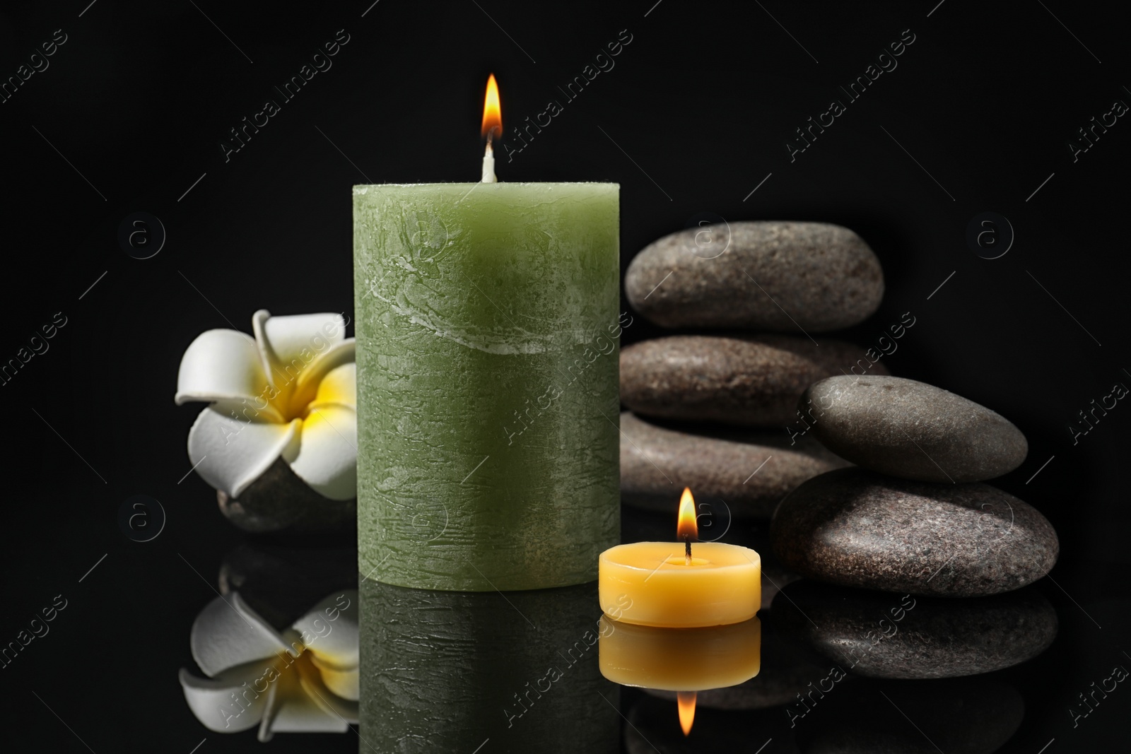 Photo of Composition with candles and spa stones on black background