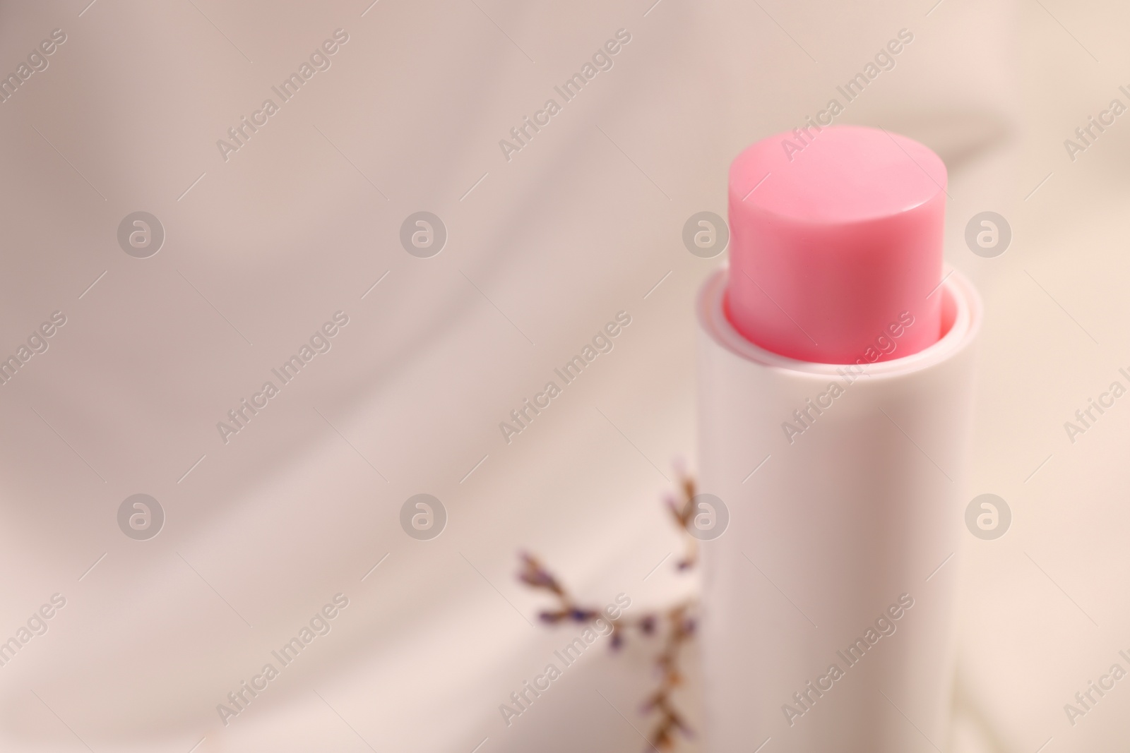 Photo of Lip balm against blurred background, closeup. Space for text