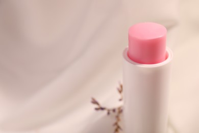 Lip balm against blurred background, closeup. Space for text