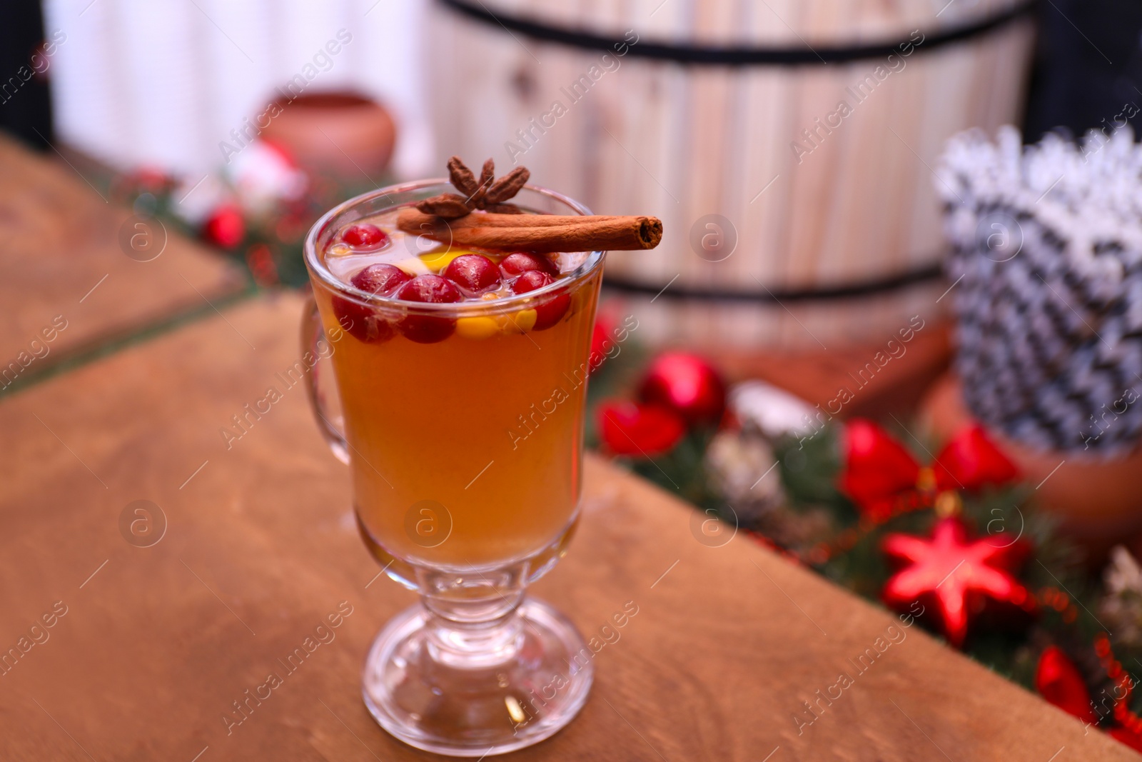 Photo of Tasty aromatic mulled wine on wooden table