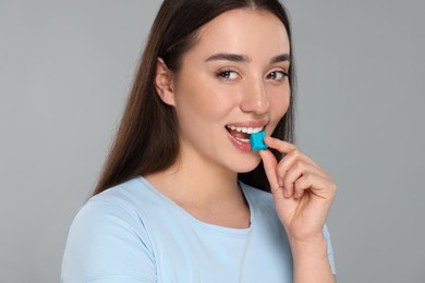 Happy young woman with bubble gum on color background