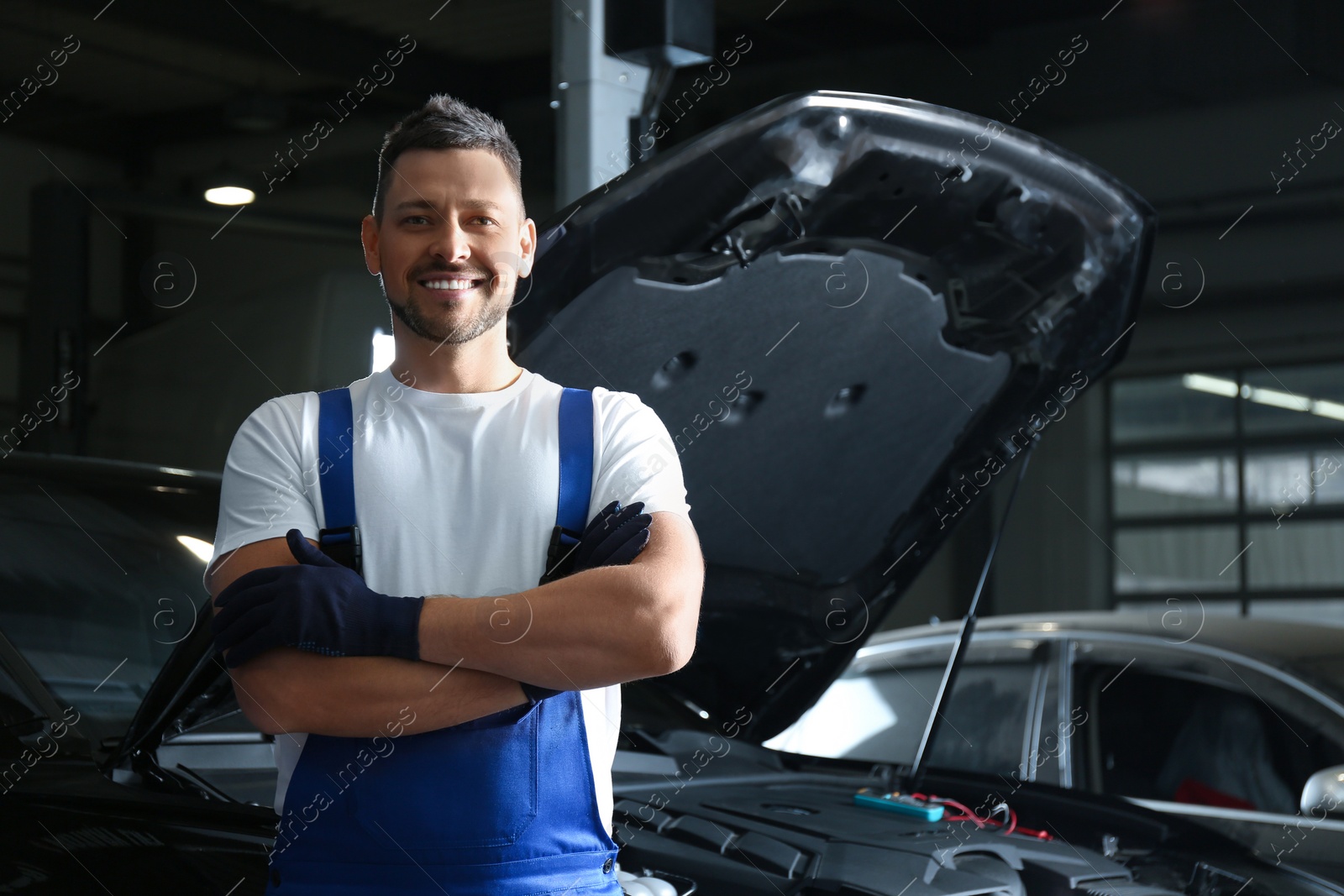 Photo of Mechanic near automobile in service center, space for text. Car diagnostic