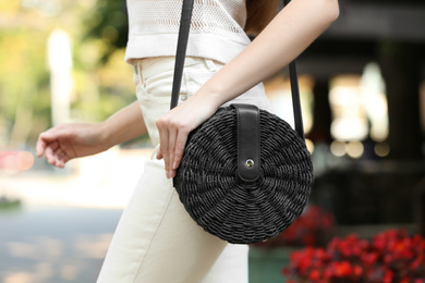 Photo of Young woman with stylish handbag outdoors on summer day, closeup