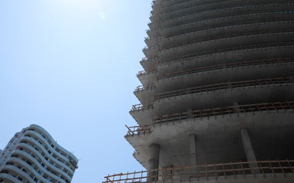 Construction site with unfinished building on sunny day, low angle view