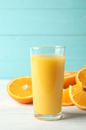 Photo of Glass of orange juice and fresh fruits on white wooden table