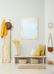 Photo of Hallway interior with wooden bench, clothes and mirror