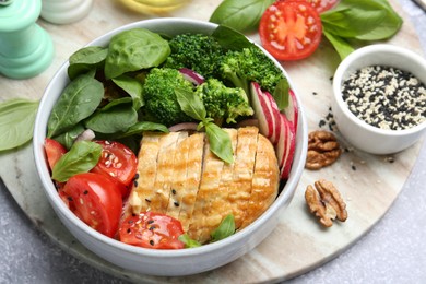 Photo of Healthy meal. Delicious chicken, vegetables and spinach served on light grey table, closeup