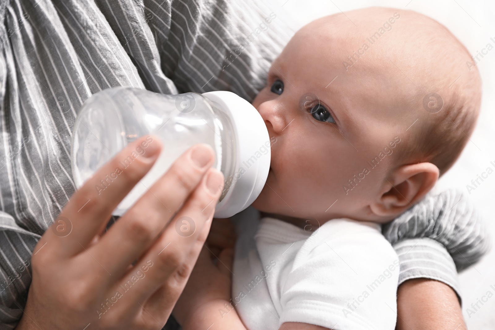 Photo of Mother feeding her little baby from bottle, closeup