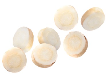 Image of Slices of fresh parsley root falling on white background