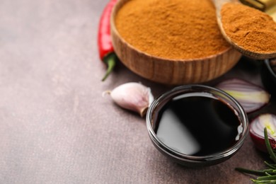 Photo of Soy sauce and different fresh ingredients for marinade on brown table, closeup. Space for text