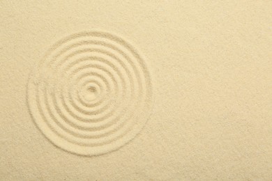 Photo of Zen rock garden. Circle pattern on beige sand, top view