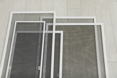 Photo of Set of window screens on wooden floor, above view