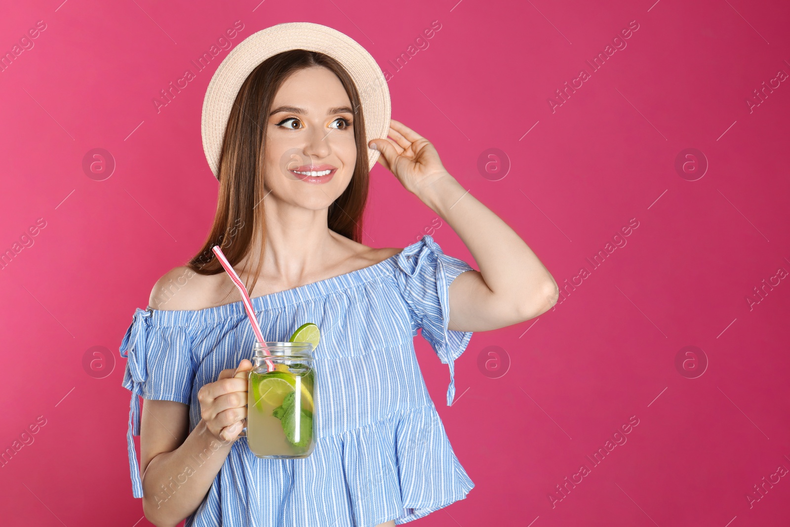 Photo of Beautiful young woman with Mason jar of natural detox lemonade on pink background. Space for text