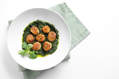 Photo of Delicious fried scallops with tasty sauce and corn salad in bowl on white table, top view. Space for text