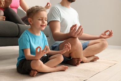 Photo of Family meditating together at home, closeup. Harmony and zen