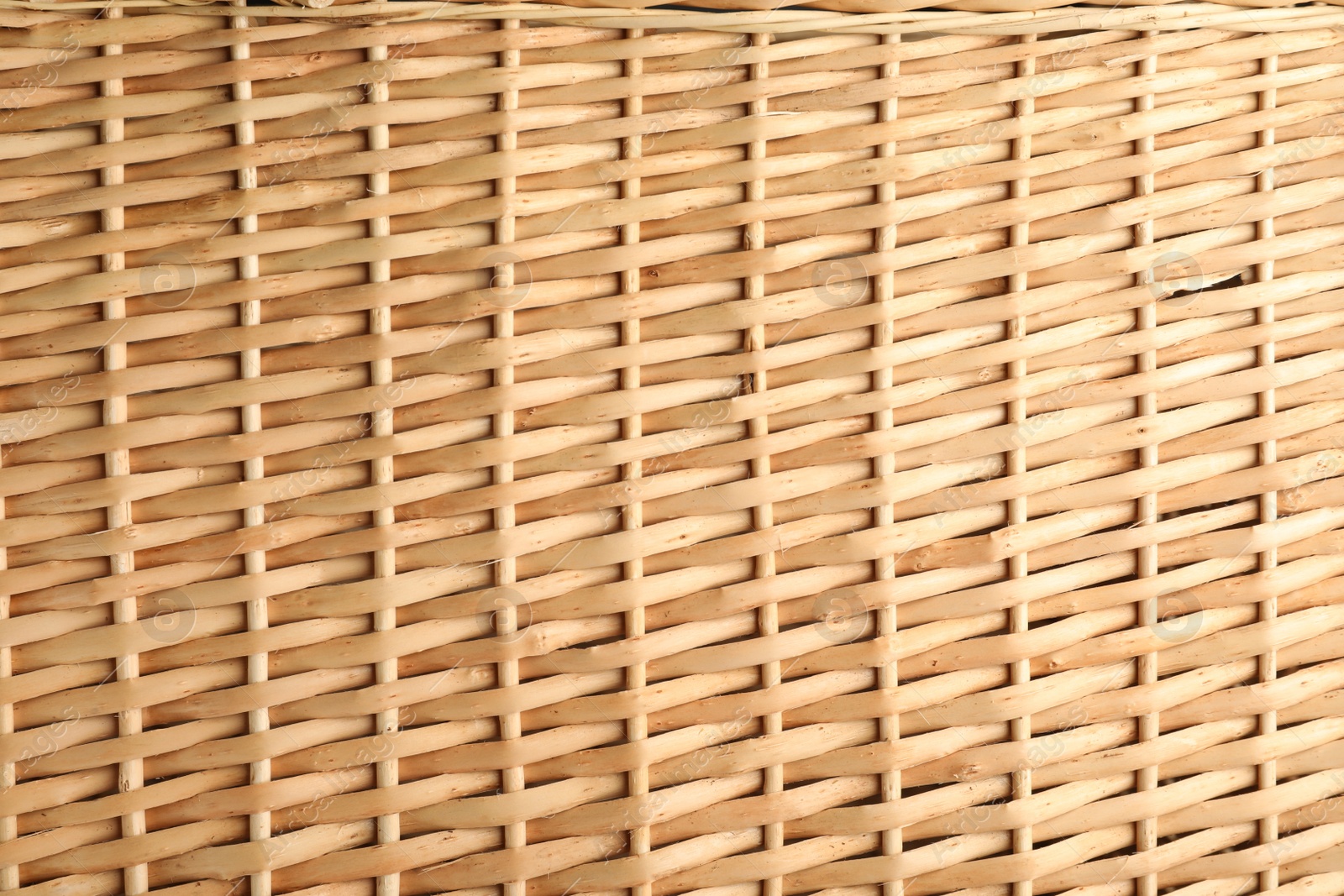 Photo of Handmade wicker basket made of natural material as background, closeup view