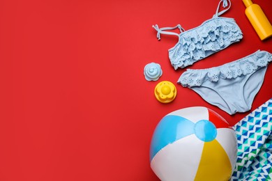 Photo of Flat lay composition with ball and beach objects on red background, space for text