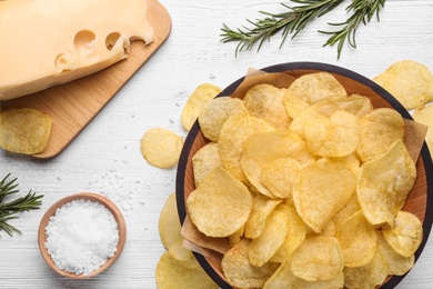 Flat lay composition with delicious crispy potato chips on table