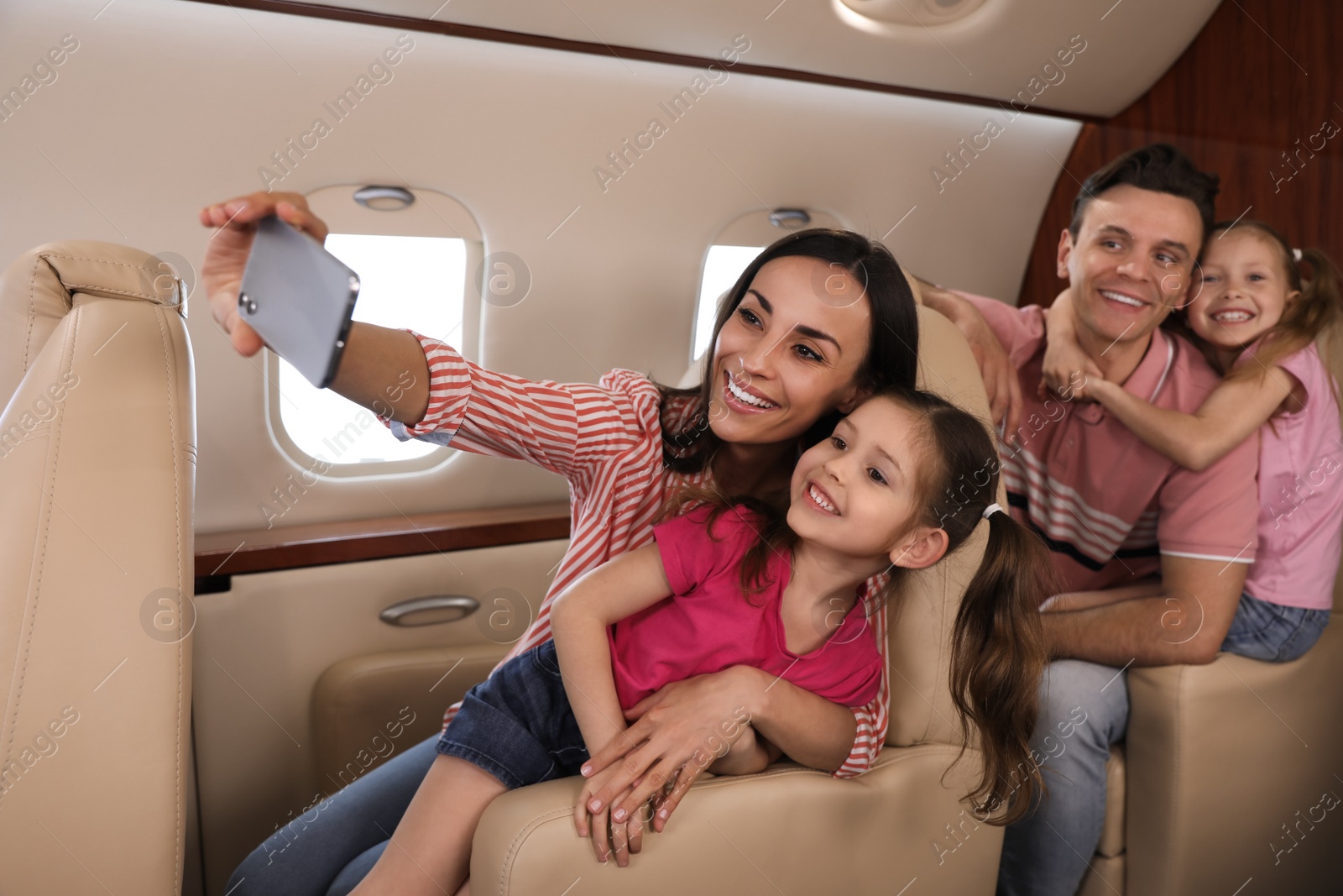 Photo of Happy family taking selfie in airplane during flight