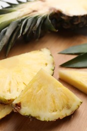 Photo of Slices of ripe pineapple on wooden board, closeup