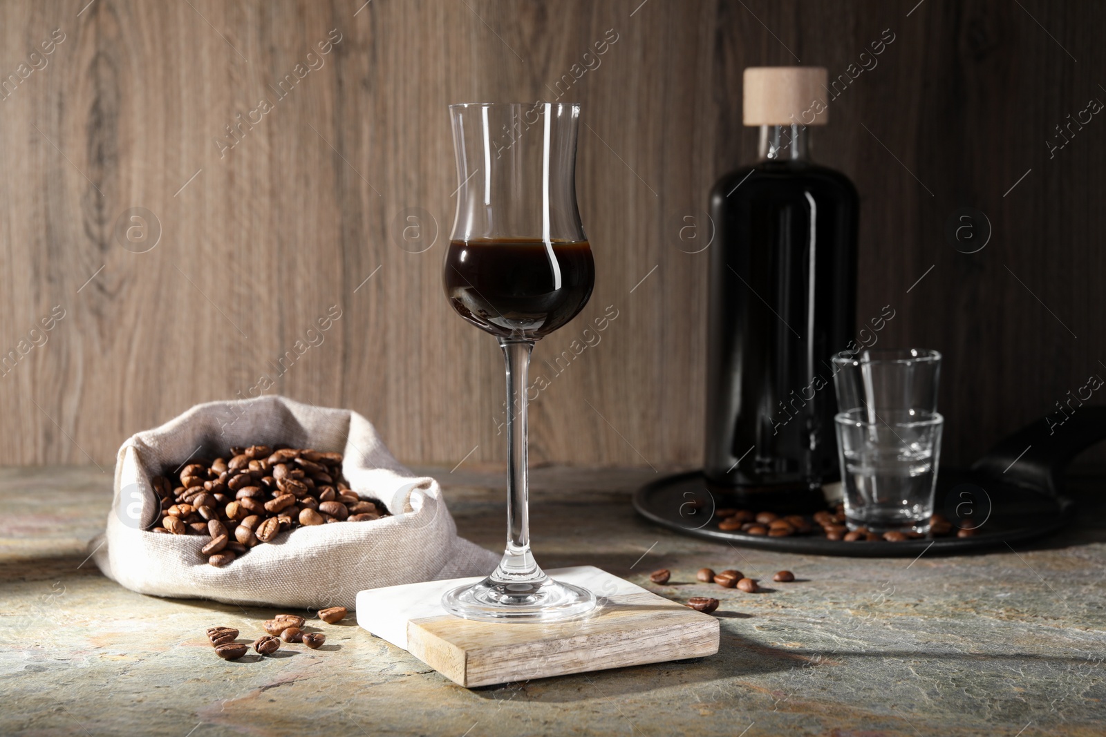 Photo of Coffee liqueur and beans on textured table