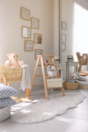 Decorative ladder with toys and different stuff in stylish baby room. Idea for interior design