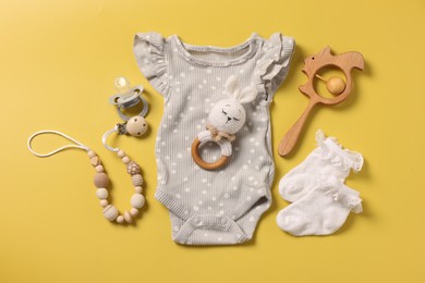 Photo of Different baby accessories on yellow background, flat lay
