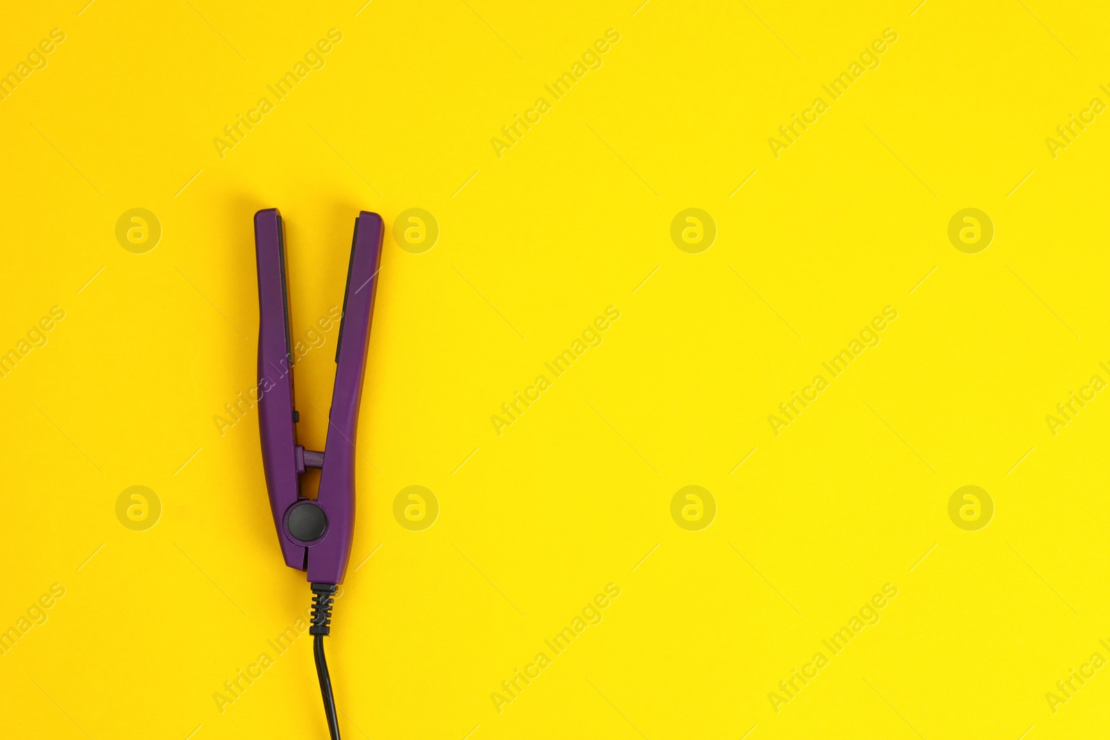 Photo of Modern hair iron for straightening on color background, top view with space for text