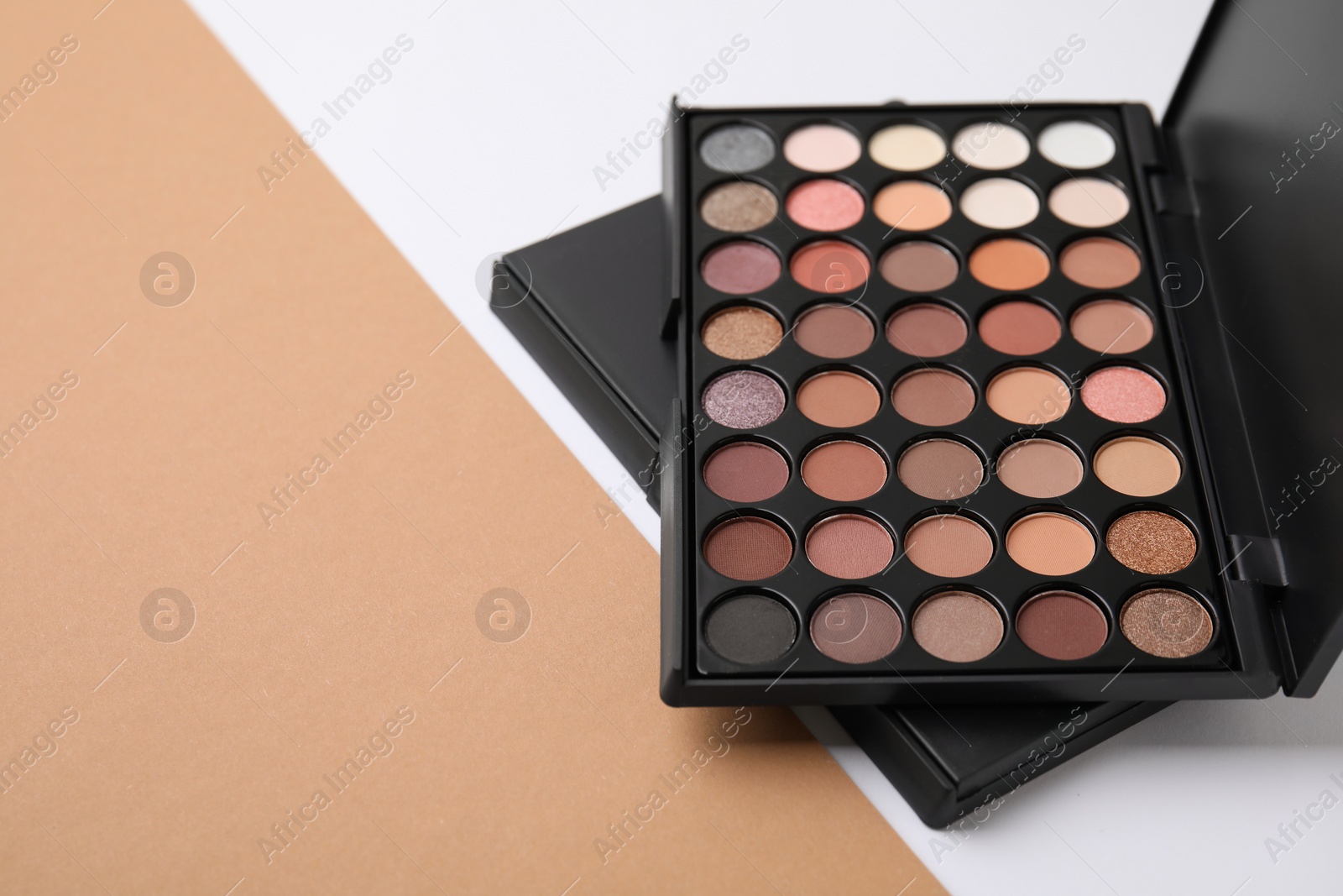 Photo of Eye shadow palette on colorful background, space for text