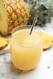 Photo of Delicious fresh pineapple juice on white marble table