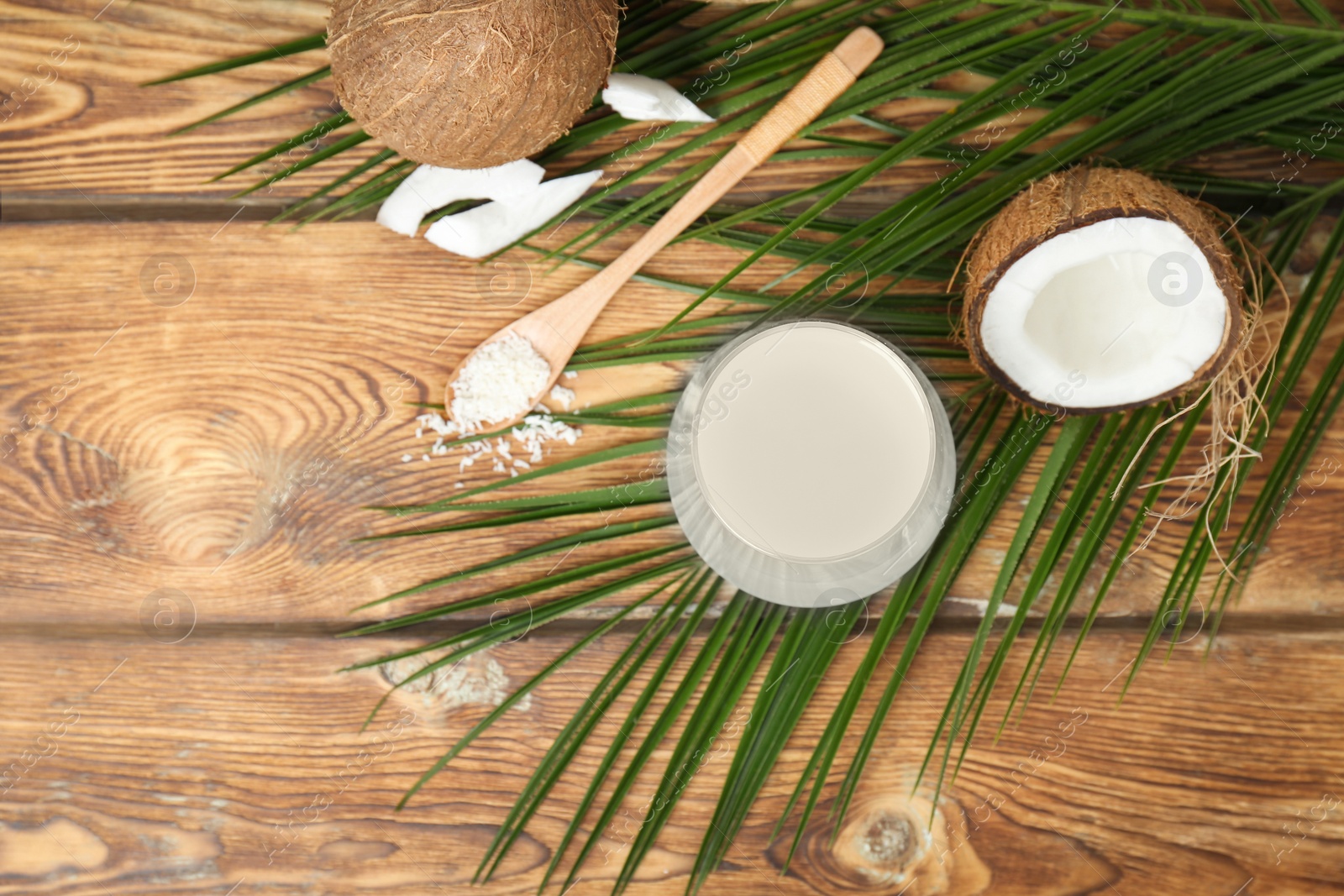 Photo of Glass of coconut water on wooden table, top view