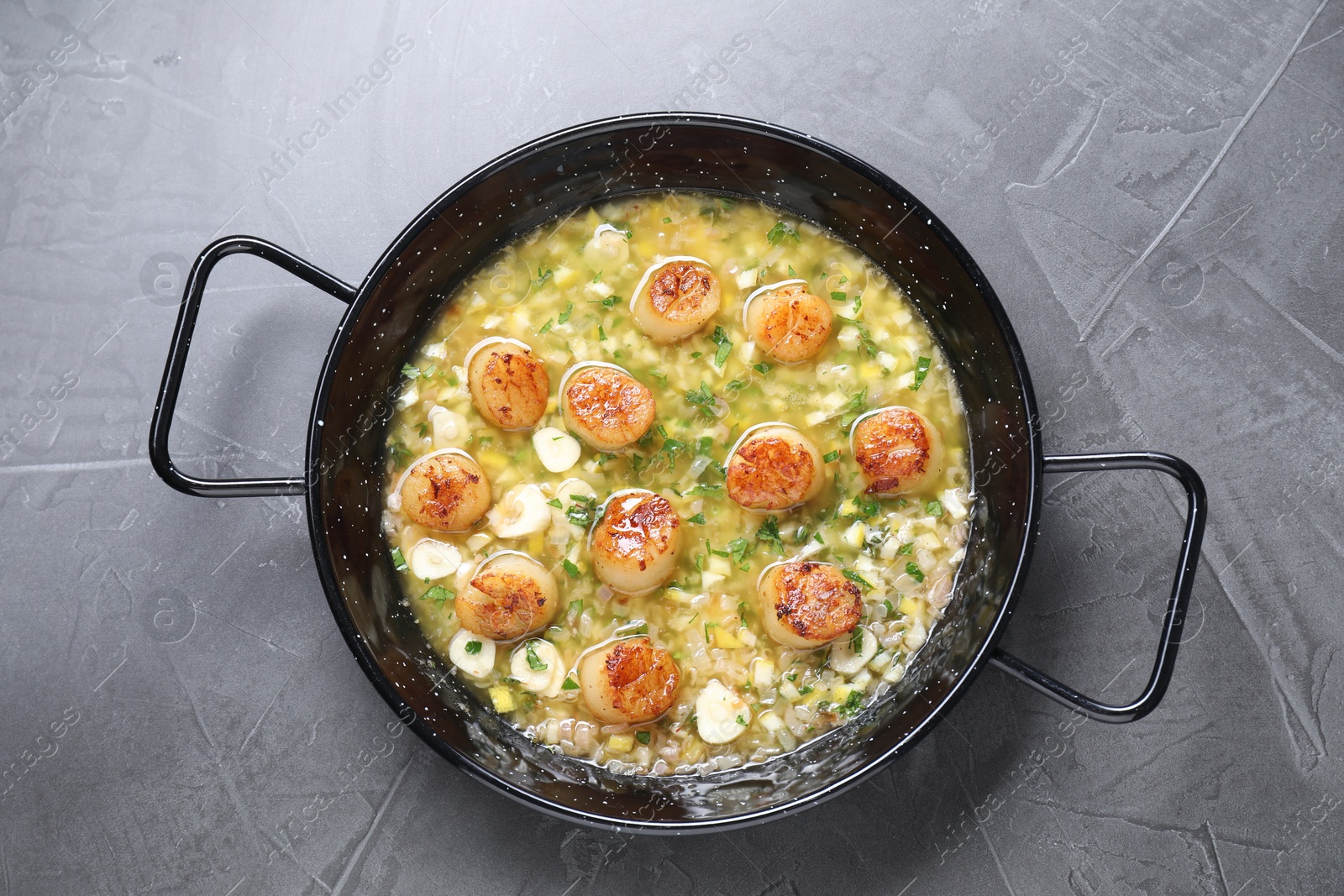 Photo of Fried scallops with sauce in dish on grey table, top view