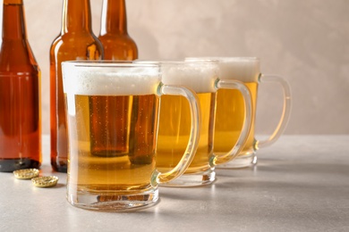 Photo of Glass mugs of cold tasty beer on table