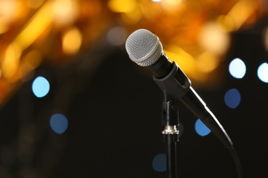 Photo of Microphone against festive lights, space for text. Musical equipment