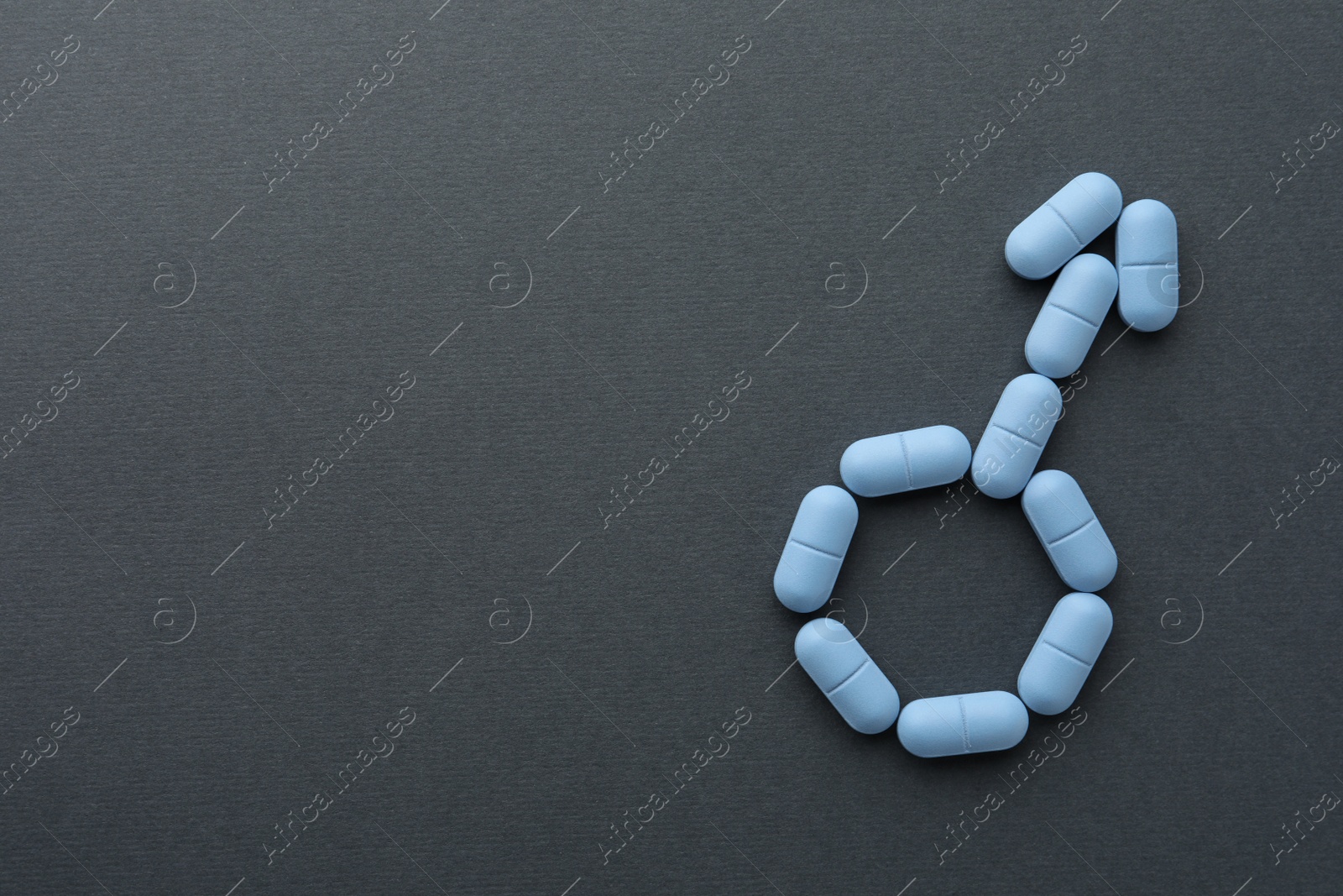 Photo of Male sign made of pills on dark gray background, top view with space for text. Potency problem