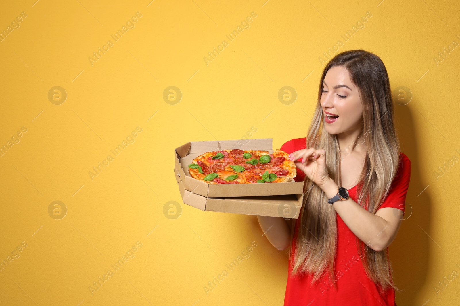 Photo of Attractive young woman with delicious pizza on color background