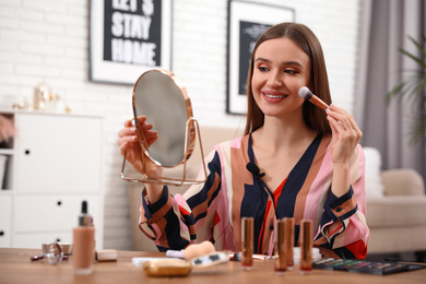Photo of Female beauty blogger doing makeup at home