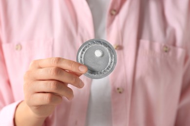 Woman holding blister of emergency contraception pill, focus on hand