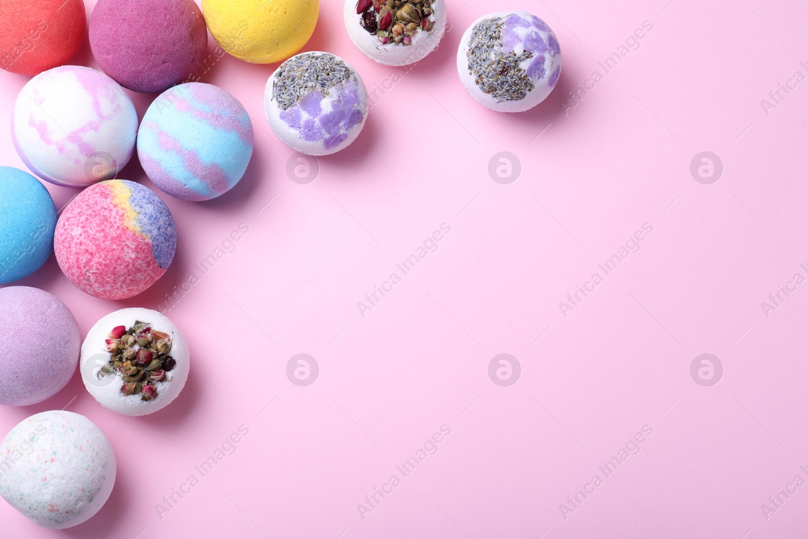 Photo of Colorful bath bombs on pink background, flat lay. Space for text