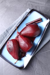 Tasty red wine poached pears and spices on grey table, top view