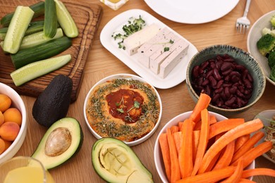 Photo of Different healthy vegetarian food on wooden table