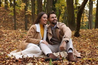 Happy young couple spending time together in autumn park