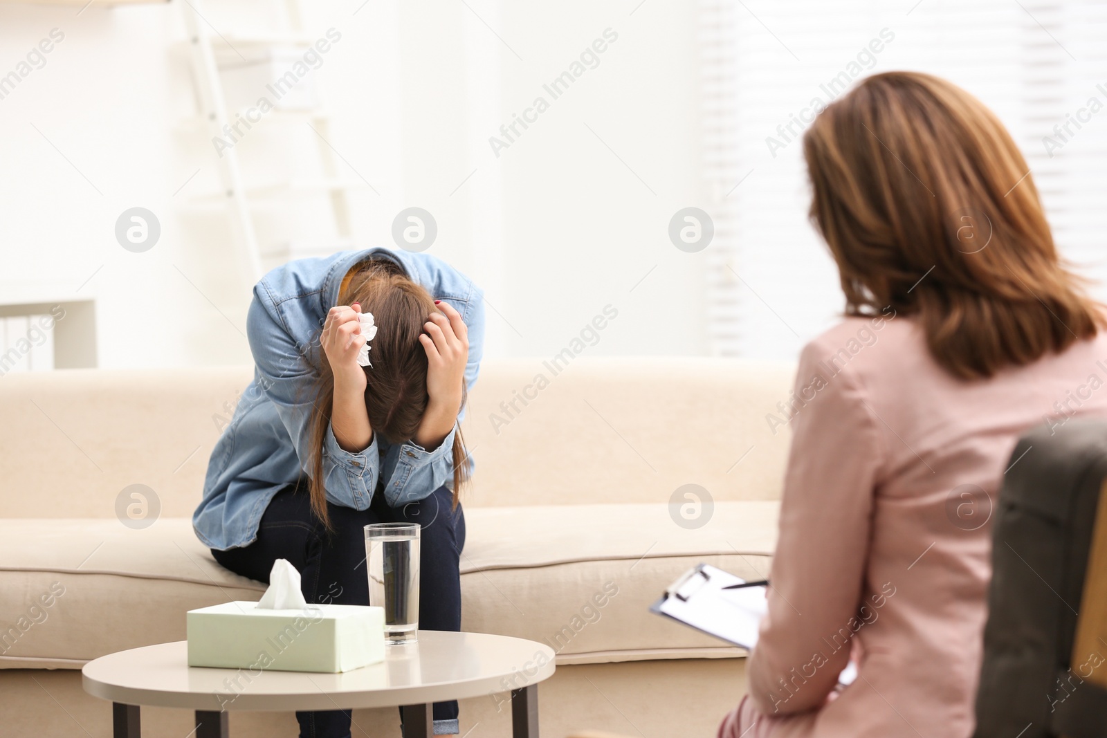 Photo of Psychotherapist working with teenage girl in office