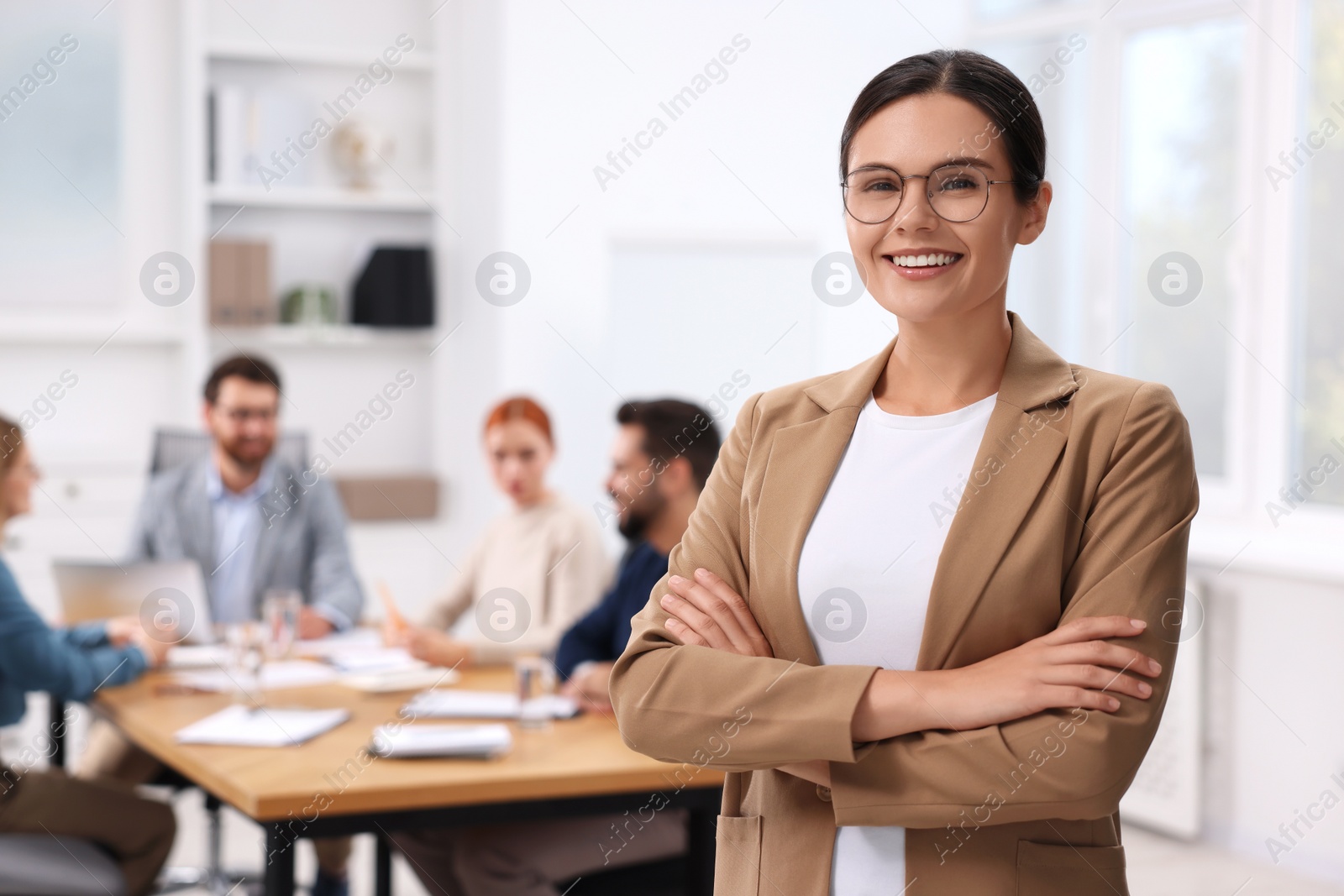 Photo of Team of employees working together in office. Happy woman indoors