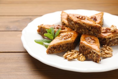 Delicious honey baklava with walnuts on wooden table, closeup